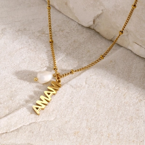 Detail of 18k gold plated necklace with MAMA letter charm and freshwater pearl pendant