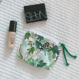 Detail of floral cotton mini pouch with green leaf print and rope zipper pull