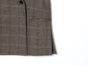 Detail of herringbone wool blazer showing flap pocket and premium resin button