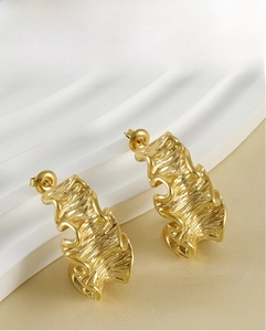 Detailed close-up of gold irregular lava-style stainless steel stud earrings with 3D texture