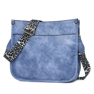 Blue faux leather crossbody bag detail featuring a bold leopard print wide shoulder strap
