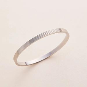 Minimalist silver titanium steel bangle featuring engraved Roman numerals on a sleek band