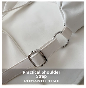 Close-up of white leather shoulder strap with silver metal buckle and fine stitching detail