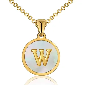 Detail of golden initial W pendant with mother of pearl inlay and polished finish