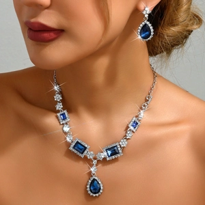 Elegant model wearing blue water-drop and square diamond necklace and earring jewelry set