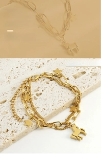 Détail macro du bracelet double couche en or 18k avec pendentifs étoile et cheval