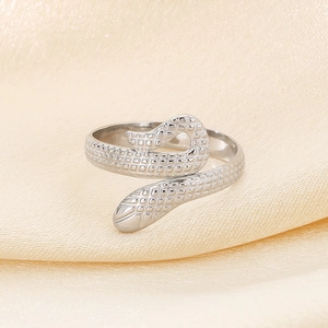 Close-up of silver snake-shaped open ring showing detailed scale texture and metallic shine