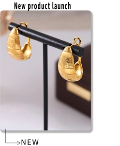 Vue détaillée de boucles d'oreilles dorées 18k avec texture grainée sur support