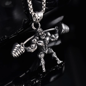 Detail of silver fitness barbell pendant showing muscular texture on a polished surface