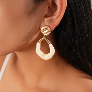 Detail of white resin drop earring on model showcasing its irregular textured shape