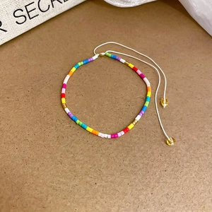 Macro shot of colorful beaded star bracelet with adjustable cord on brown background