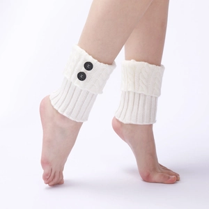 Detail of white cable knit leg warmers with vintage button accents on the side