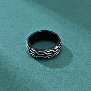 Men's industrial tire tread ring in black and silver steel on a dark background