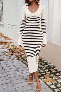 Détail d'une robe en maille beige à col en V avec des rayures noires horizontales