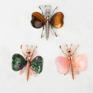 Three crystal butterfly crafts with tiger eye and quartz wings on a white backdrop