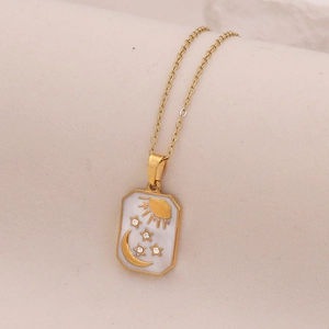 Detailed close-up of a golden rectangular pendant with celestial sun and moon enamel design