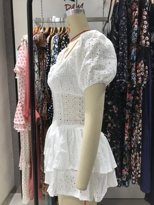 Detalle de vestido de encaje blanco con mangas abullonadas y bordado inglés intrincado