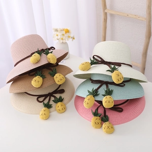 Détail de chapeaux de paille pour enfants en six couleurs avec breloques ananas
