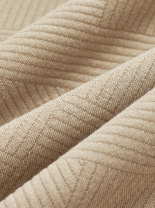 Close-up of khaki jacquard knit fabric showing detailed twill texture and soft material