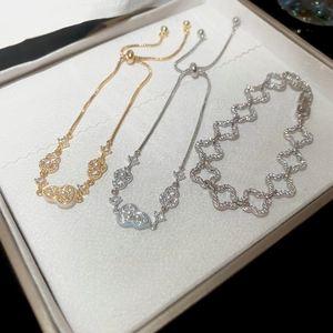 Detailed close-up of 18k gold plated bracelets with zircons, pearls, and gourd charm