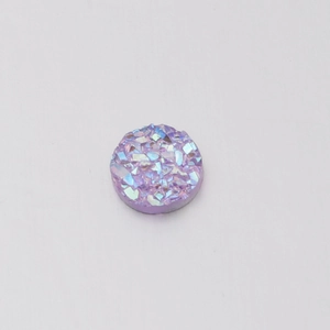 Macro detail of 6mm resin flatback stone with iridescent pink and purple crystal textures