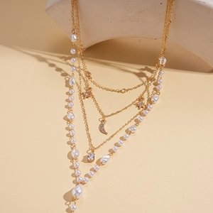 Macro detail of layered necklace with star moon pendants and imitation pearls