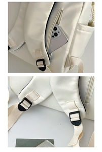 Detail of white backpack featuring a hidden anti-theft back pocket and adjustable strap buckle