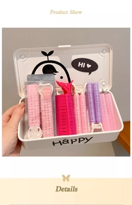 Close-up of pink and purple hair rollers set in a white storage box with clips