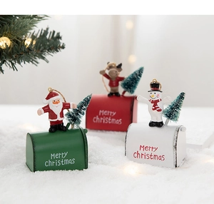 Close-up of three festive metal Christmas mailboxes with Santa, elk, and snowman figures