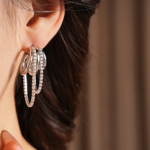 Gros plan de boucles d'oreilles multicouches en argent et zircon sur un mannequin