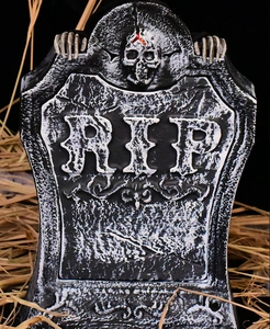 Macro detail of Halloween RIP tombstone with skull relief and stone texture