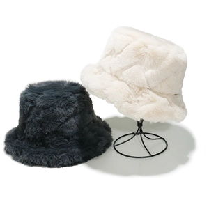 Detail of plush faux fur bucket hats in black and cream with thick warm texture