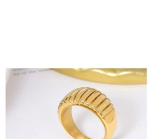 Macro detail of gold plated croissant ring showing polished ribbed texture and metallic finish