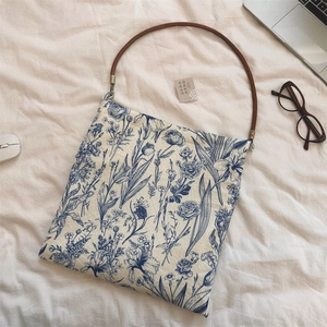 Detail of vintage floral blue and white porcelain pattern cotton shoulder bag with round handle