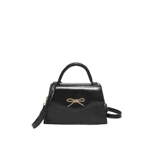 Mini sac à main noir avec noeud doré et bandoulière amovible sur fond blanc élégant