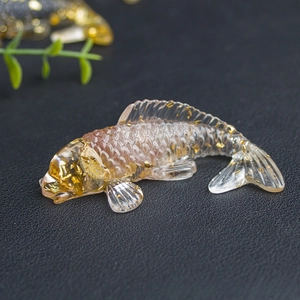 Detailed close-up of a resin koi fish figurine with embedded gold leaf on black surface
