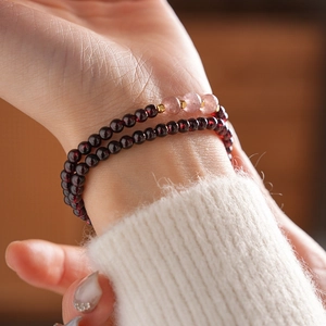 Detail of garnet beaded bracelet with strawberry quartz and gold spacers on wrist
