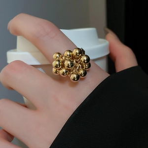 Close-up of a gold cluster ball ring on a hand for a stylish minimalist jewelry look