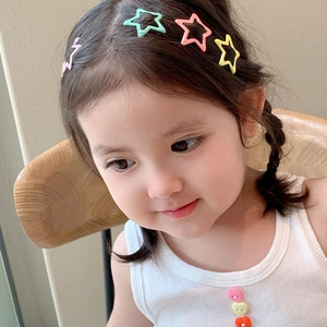 Close-up of a child wearing macaron-colored star and lightning bolt shaped hair clips