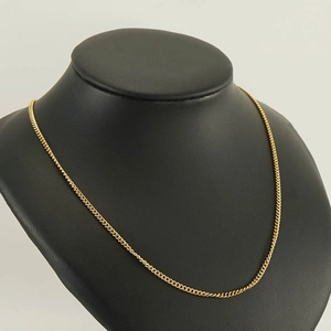 Collier gourmette minimaliste en acier inoxydable doré présenté sur un buste noir