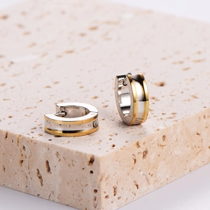 Two-tone silver and gold stainless steel hoop earrings with center groove on stone base