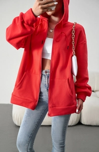 Close-up of red zip-up hoodie featuring warm fleece fabric and ribbed cuffs detail