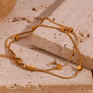 Detail of 18K gold plated double layer snake chain with gold bead charms and lobster clasp