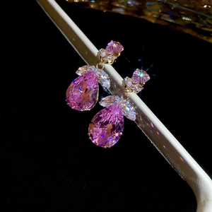 Vue macro de boucles d'oreilles poire en zircon rose avec dorure et motif de feuilles