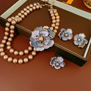 Macro detail of vintage floral jewelry set with pink enamel pearls and gold accents