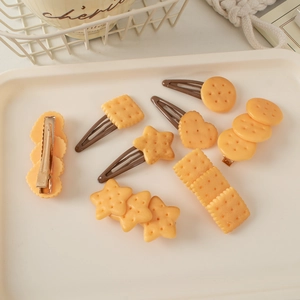Detail of realistic resin cookie hair clips in various shapes on a decorative tray