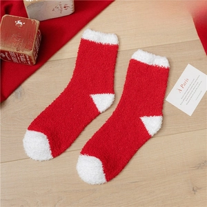 Detail of red and white coral fleece Christmas socks on a festive wooden background