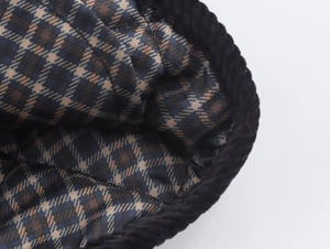 Detail of blue and brown plaid lining with black corduroy trim on a quilted jacket
