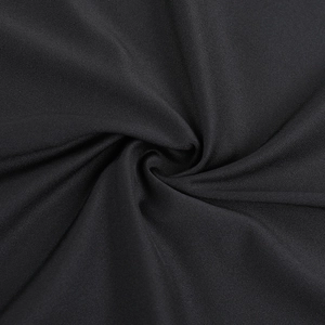 Gros plan sur la texture du tissu en maille noire avec drapé en spirale et ombres douces
