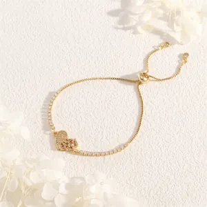 Detail of adjustable gold heart bracelet with sparkling zircon inlay and slider clasp